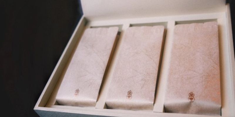 三只独立包装的茶包并排放在打开的礼盒里