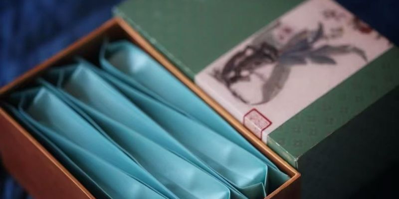 A Baoputang gift box on a deep blue table setting