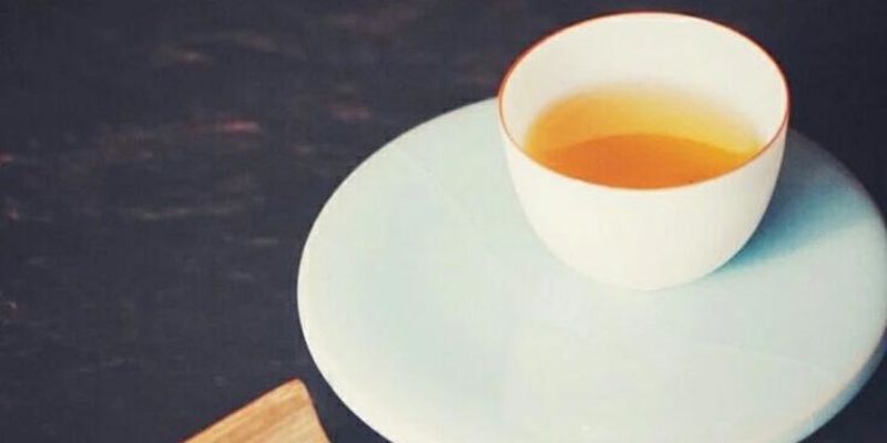 一堆深色的烟熏干茶叶铺在木板上